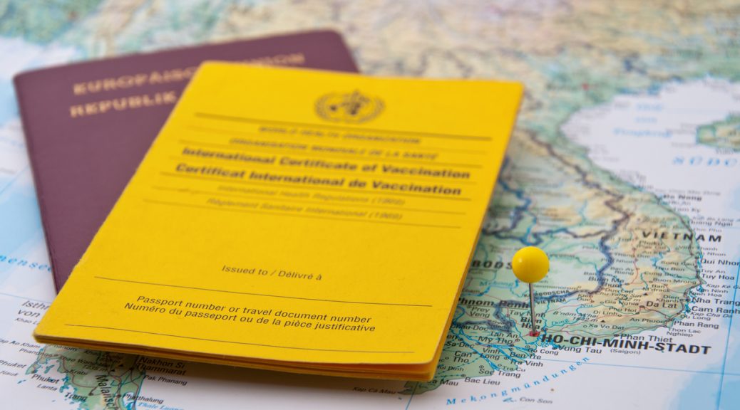 Close Up of Vaccination Certificate, Passport and Ho Chi Minh Pin at map.