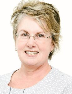 Nurse Practitioner Christine Schoenfisch headshot, white background wearing grey blouse and glasses